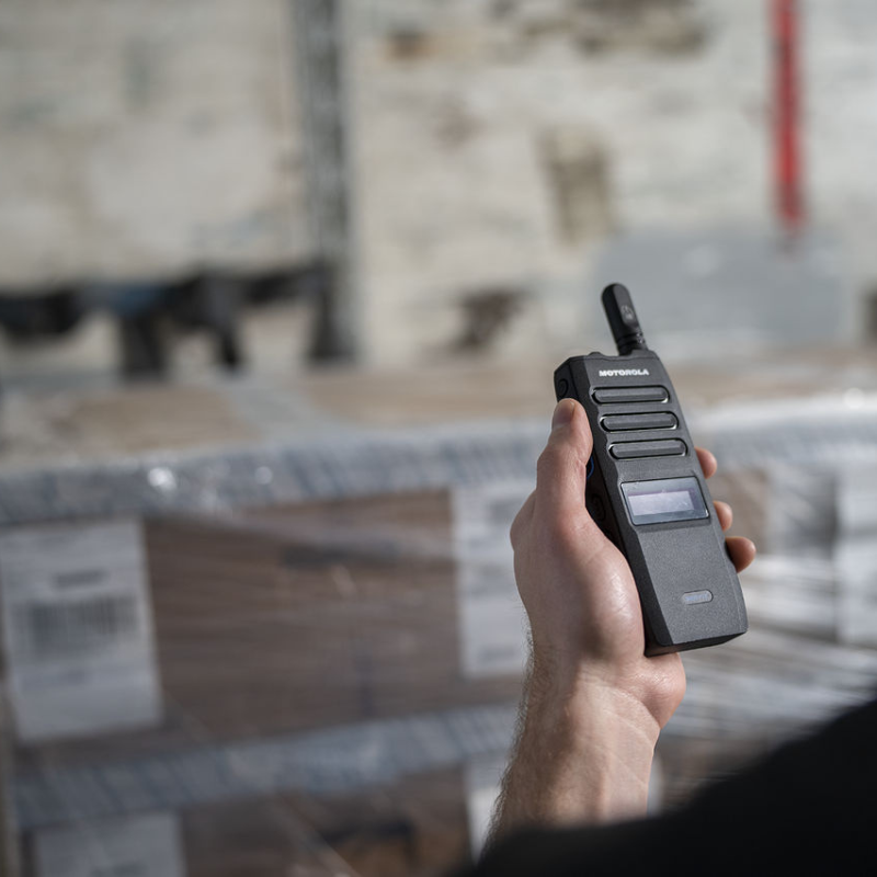 A man holding a Motorola TLK110