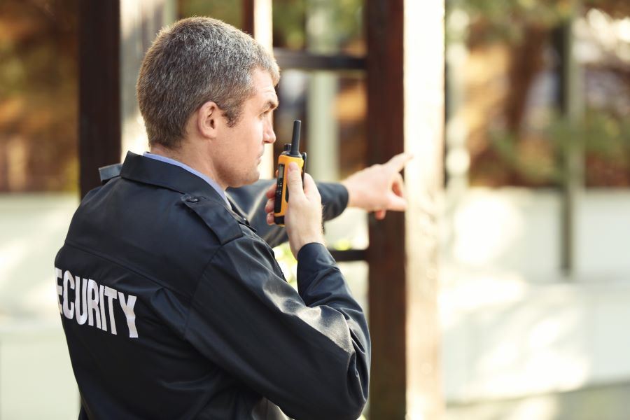 Male security guard using two-way radio